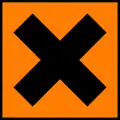 A square orange sticker with a black cross on it.