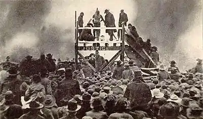 Crowd watching a lynching on stage