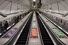 View up the inclined main escalator shaft with four escalators in a line carrying passengers up and down.