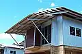 Hardwood purlins fixed to steel supports on a skillion roof and main roof. House under construction, tropical North Australia.