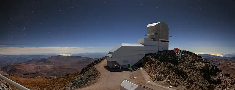 Night Light over Vera C. Rubin Observatory with the brightening of the sky due to the artificial light which can be seen as clusters of bright lights on the horizon.