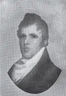 A man with thick, black hair wearing a white shirt and dark jacket