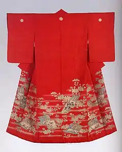 The back view of a scarlet red kimono with medium-length sleeves. The kimono has a warm red lining and a padded hem, and is decorated with three white crests and a hand-painted design of hazy mist, hanging scroll motifs and flowers.