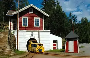 Yellow locomotive leaving the basement of a building