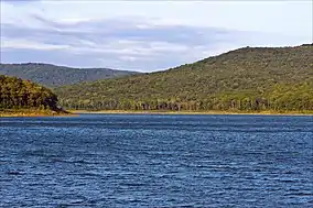 Shining blue water with the Ozark Mountains rising in the background