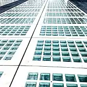 A close-up of a similar grid of glass squares, slightly blueish glass with a wavy lower surface, in full sunlight.