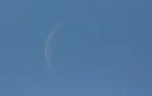 venus next to a crescent moon in the blue daytime sky