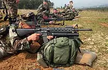 A U.S. Marine takes aim with an M16A2 fitted with the M203 40 mm grenade launcher.