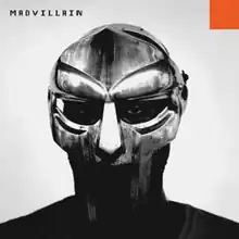 Grayscale photo of Doom's face behind his metal mask, with the word "MADVILLAIN" in pixelated black font at the top left corner and a small orange square at the top right corner.