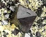 Octahedral crystals of magnetite up to 1.8 cm across, on cream colored feldspar crystals, locality: Cerro Huañaquino, Potosí Department, Bolivia