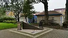 A bronze sculpture depicting two children playing while two others look on.