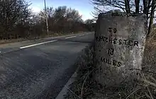 A milestone along the Warrington and Lower Irlam turnpike road, near Rixton.  The opposite side gives the distance to Warrington.