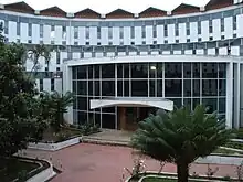 Multi-story, curved modern building of concrete and blue glass