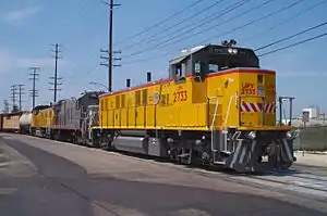 An NRE 3GS21B leads a Union Pacific train along street running trackage at Anaheim, California.