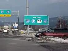 A big green sign reads "Junction I-87, New York Thruway, NY 32, and Orange County Route 64".