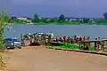 Bank of Oguta Lake showing human activities and rural dwellers. These includes motorcyclists,loaded pontoon and automobile drivers engaged in movement of goods, services and people.