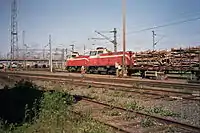 Two diesel locomotives (class Dv12) transporting wood at the Oulu train station freight yard.