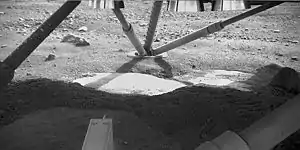 View underneath lander towards south foot pad, showing patchy exposures of a bright surface, possibly ice.