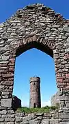 The 10th or 11th century round tower viewed through the window of St. Patrick's Church