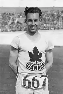 Man wearing a white track and field bib with a maple leaf logo