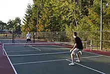 Two men playing pickleball at a dedicated court