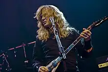 Red-haired guitarist in a black shirt in front of a microphone