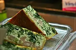 Slices of a quiche with a green and yellow fillings