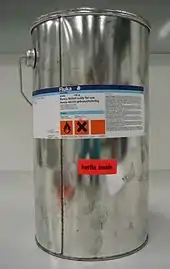 Shiny metal can with hazard labels.