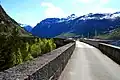 Road on the top of the dam and a spillway with five slide gates.