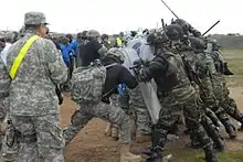 Soldiers from Kansas and Armenia practice a riot control exercise