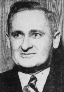 Black and white facial photo of a middle-aged man in a suit and tie