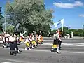 Students and teachers in traditional clothing march in a procession in Liiva