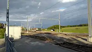 Single-story building next to double-track railway line with side platforms