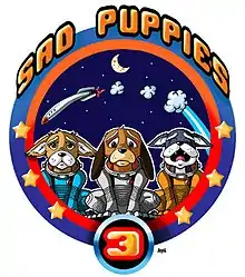 A mission patch, laid out like an Apollo mission patch with three cartoon sad puppies, in spacesuits but no helmet, in the foreground, and a crashing rocket behind them, against a backdrop of crescent moon and stars