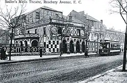 exterior of a theatre building with substantial portico parallel to a main road