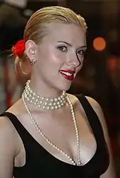 A photograph of Scarlett Johansson wearing a black dress and a pearl necklace.