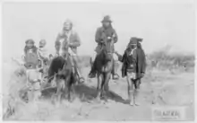 Image 33"Geronimo's camp before surrender to General Crook, March 27, 1886: Geronimo and Natches mounted; Geronimo's son (Perico) standing at his side holding baby." By C. S. Fly. (from Photojournalism)