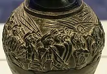 Close-up shot of the shoulder of the vase, showing numerous closely-packed figures with open mouths