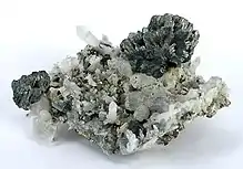 A spray of semseyite crystals perched, freestanding, at the apex of a cluster of quartz crystals