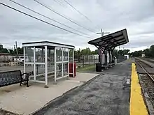 A large canopy and small shelter on a railway platform