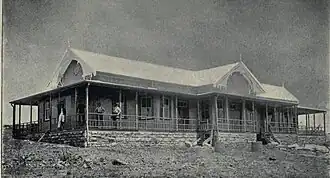 Workers standing on the veranda of a Dutch-style building