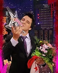 Nader Guirat winner of Star Academy 5 carrying the Tunisian flag and the trophy on stage at the show's finale on 23 May 2008