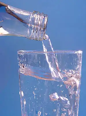 Water flowing from a bottle into a glass.