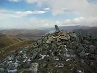 The summit cairn on Sheffield Pike, with stone boundary marker, and Ullswater beyond