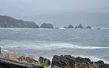 Photo of rocks protruding from ocean.