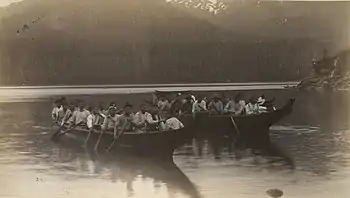 Photo of two large canoes with many rowers