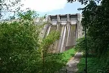 Large gray concrete dam, viewed from below