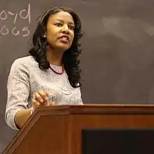 Jones speaking behind a podium during a 2017 debate