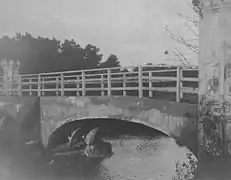 The repaired bridge. Note the simple wooden handrail and the remaining exposed iron arch.