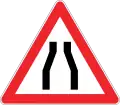 Road narrows on both sides